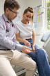 © Austockphoto - Male doctor holding a tablet  and talking to a female patient in the clinic