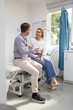 © Austockphoto - Male doctor holding a tablet  and talking to a female patient in the clinic