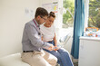 © Austockphoto - Male doctor holding a tablet  and talking to a female patient in the clinic