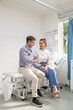 © Austockphoto - Male doctor holding a tablet  and talking to a female patient in the clinic