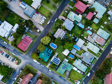 Top Down Overhead View Of Houses With Pools In Backyard And Streets