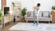 © Puwasit Inyavileart - Beautiful woman vacuuming the floor and carpet in her living room, Big cleaning in the house, Removes germs, Housewife cleaning, Keeping her home clean, Domestic hygiene.