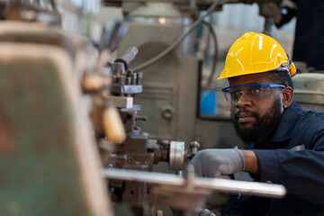 Wall Mural - Male factory worker working or maintenance with the machine in the industrial factory while wearing safety uniform and hard hat