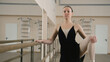 © Framestock - Adult woman in training bodysuit stands front of ballet barre in dance studio, stretches and prepares for performance. Graceful Ballet dancer doing gymnastic exercises. Classical ballet dance school.
