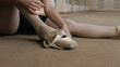 © Framestock - Close up shot of female ballet dancer taking off her pointe shoes after stretching and gymnastic workout in dance studio. Ballerina finished choreography rehearsal. School of classical ballet dance.