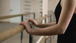 © Framestock - Ballerina in training bodysuit stands near ballet barre in dance studio, stretches her leg and prepares for performance. Female ballet dancer doing gymnastic exercises. Classical ballet dance school.