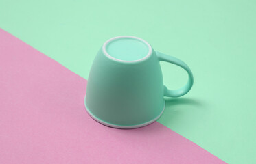 Wall Mural - Inverted cup on a blue-pink pastel background. Minimal layout