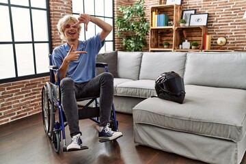 Poster - Young man sitting on wheelchair at for motorcycle accident smiling making frame with hands and fingers with happy face. creativity and photography concept.