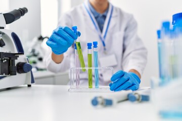 Wall Mural - Young blond man scientist holding test tube at laboratory