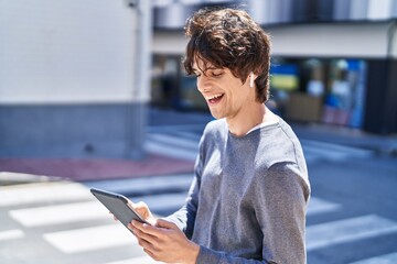 Sticker - Young hispanic man smiling confident listening to music at street