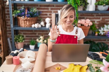 Sticker - Young blonde woman working at florist shop doing video call looking positive and happy standing and smiling with a confident smile showing teeth