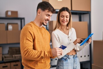 Wall Mural - Young man and woman ecommerce business workers using touchpad and credit card at office