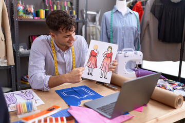 Poster - Young hispanic man tailor having video call showing clothing design at atelier