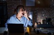 © Krakenimages.com - Beautiful brunette woman working at the office at night shouting and screaming loud to side with hand on mouth. communication concept.
