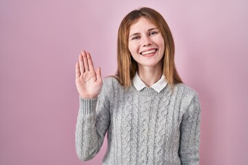 Sticker - Beautiful woman standing over pink background waiving saying hello happy and smiling, friendly welcome gesture