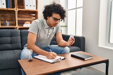 Wall Mural - Young hispanic man psychologist prescribe pills at psychology center