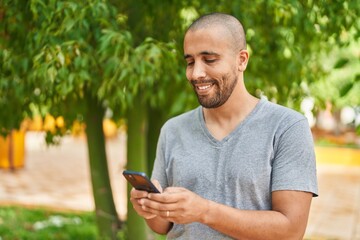 Sticker - Young latin man smiling confident using smartphone at park