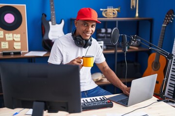 Poster - Young latin man musician having dj session drinking coffee at music studio