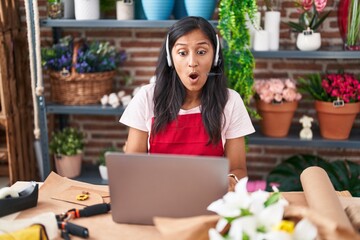 Sticker - Young hispanic woman working at florist shop doing video call scared and amazed with open mouth for surprise, disbelief face