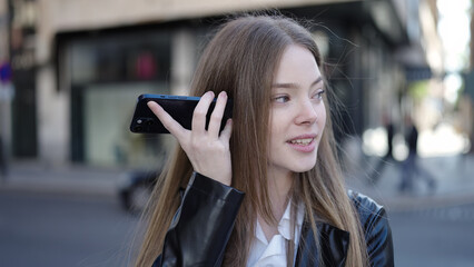 Sticker - Young blonde woman smiling confident listening audio message by the smartphone at street