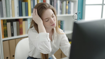 Canvas Print - Young blonde woman student using computer stressed at university classroom