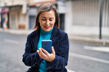 Sticker - Middle age woman business executive using smartphone at street