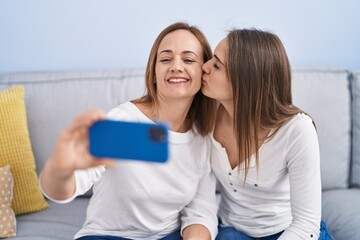 Sticker - Two women mother and daughter make selfie by smartphone at home