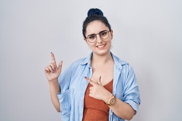 Poster - Young modern girl with blue hair standing over white background smiling and looking at the camera pointing with two hands and fingers to the side.