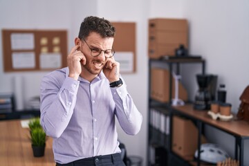 Sticker - Young hispanic man at the office covering ears with fingers with annoyed expression for the noise of loud music. deaf concept.