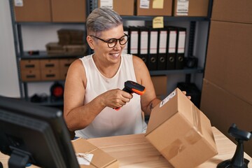 Sticker - Middle age woman ecommerce business worker scanning package at office