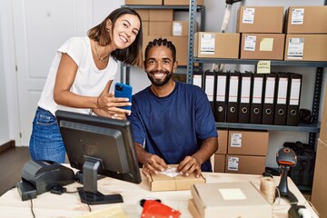 Canvas Print - Man and woman business partners using smartphone and packing order at storehouse