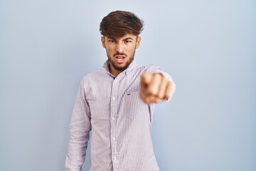 Canvas Print - Arab man with beard standing over blue background pointing displeased and frustrated to the camera, angry and furious with you