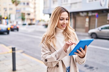 Poster - Young blonde woman smiling confident using touchpad at street