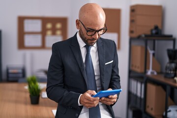 Canvas Print - Young bald man business worker using touchpad at office