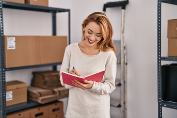 Wall Mural - Young woman ecommerce busines worker writing on notebook at office