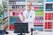 © Krakenimages.com - Young caucasian woman working at pharmacy drugstore with a big smile on face, pointing with hand and finger to the side looking at the camera.