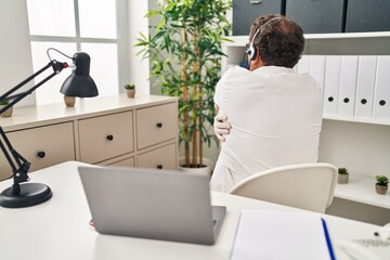 Wall Mural - Senior doctor man working on online appointment hugging oneself happy and positive from backwards. self love and self care