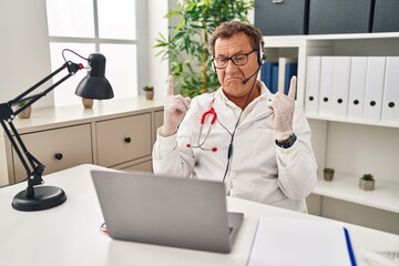 Poster - Senior doctor man working on online appointment pointing up looking sad and upset, indicating direction with fingers, unhappy and depressed.