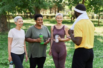 Wall Mural - Diverse group of senior women enjoying outdoor sports training and talking to coach