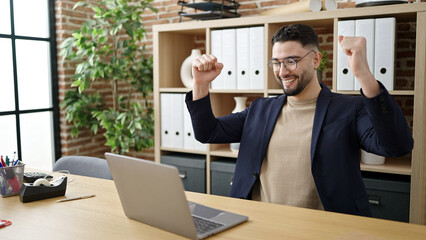 Wall Mural - Young arab man business worker using laptop with winner expression at office