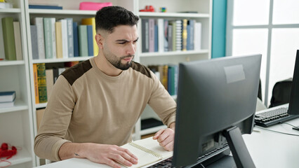 Wall Mural - Young arab man student using computer studying with doubt expression at university classroom