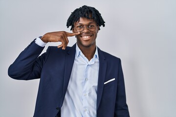 Canvas Print - Young african man with dreadlocks wearing business jacket over white background pointing with hand finger to face and nose, smiling cheerful. beauty concept