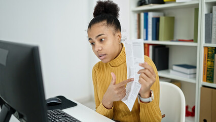 Young african american woman on video call explaining paper at the library