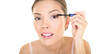© Maridav - Beauty makeup woman putting mascara eye make up on eyes. Asian fresh face girl looking in the mirror looking at camera isolated in transparent PNG. Mixed race ethnic Asian Chinese / Caucasian model.