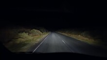 Driver perspective at night in the dark. Person point of view driving on empty road in countryside