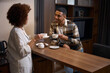 © Svitlana - Traveling multiracia spouses chatting over morning coffee in hotel room