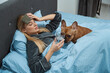 Sick woman and her French bulldog in bedchamber
