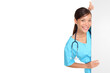 Nurse showing sign billboard blank with copy space. Woman medical professional in scrubs wearing stethoscope smiling friendly isolated cutout PNG on transparent background.