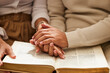 © Joanrae P/peopleimages.com - Closeup, hands and couple with bible, praying and support with love, spiritual and religious practice. Zoom, hand and man with woman, prayer and scripture for faith, trust and wellness with bonding
