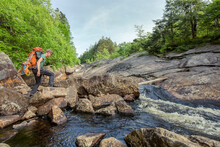 A Rock Climber Crosses A Stream In Upstate New York.